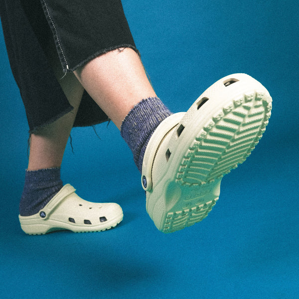 crocs clogs stucco white with purple socks fashion shoot